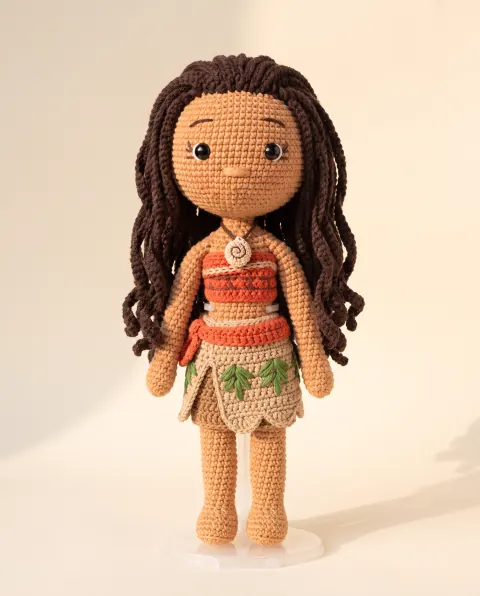 Muñeca de cabello largo castaño con falda de hojas y collar de caracol